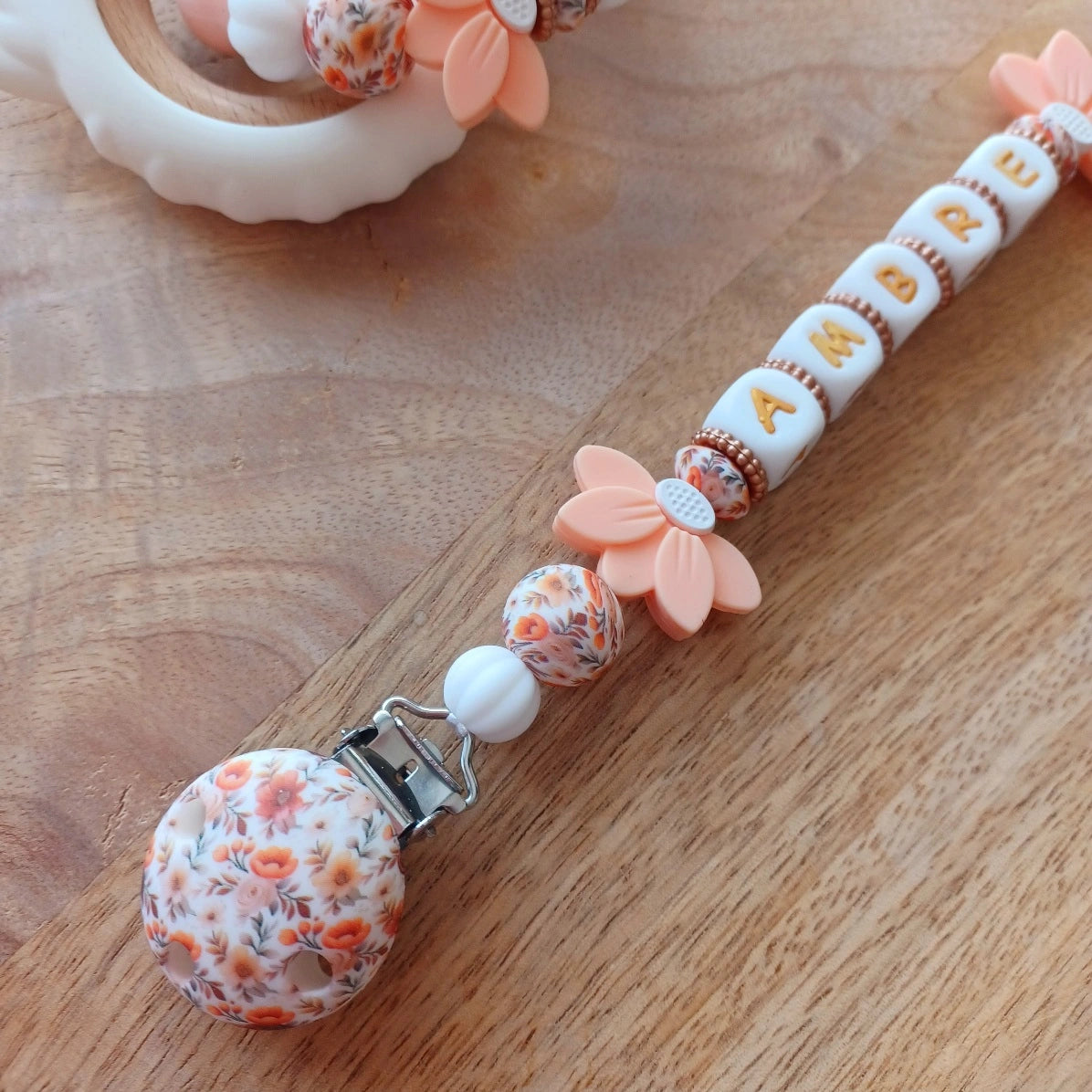 Attache tétine silicone perles imprimées, cadeau naissance, Lotus abricot-blanc. Ambre