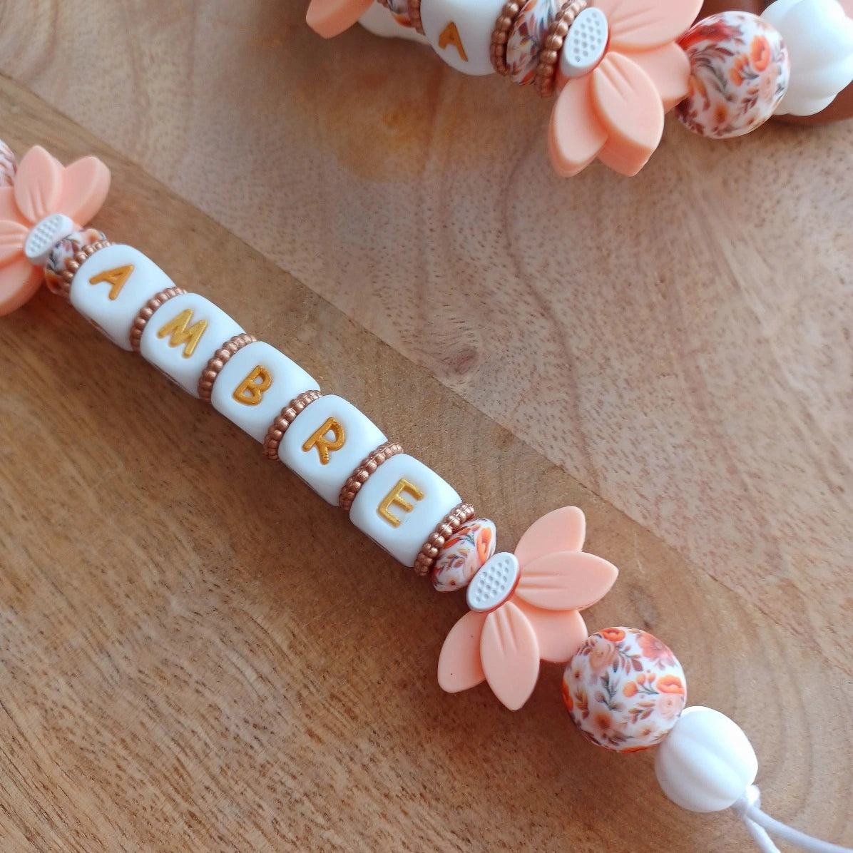 Attache tétine silicone perles imprimées, cadeau naissance, Lotus abricot-blanc. Ambre