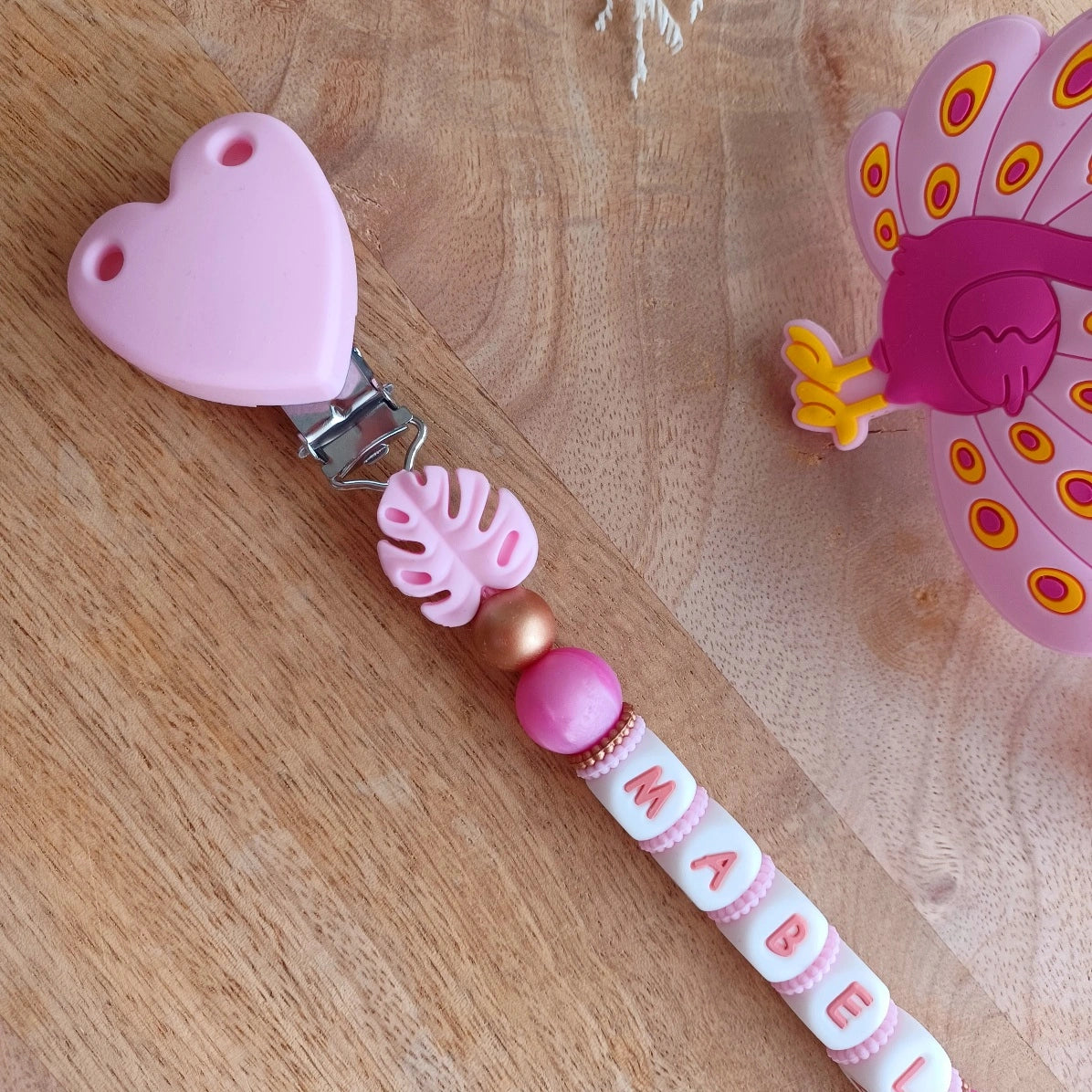 🌸 Attache-tétine personnalisée prénom – Coeur & paon. Mabel