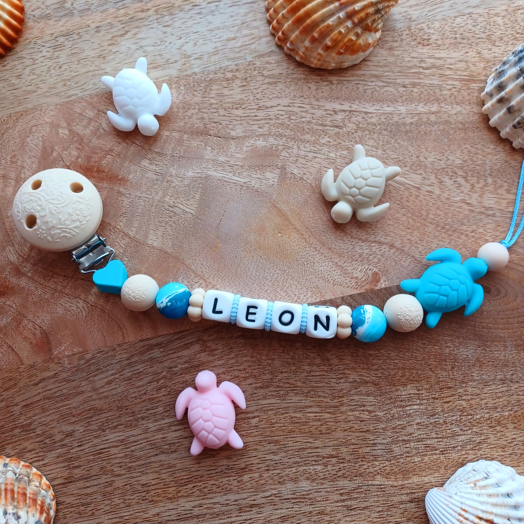 Attache tétine en silicone alimentaire, cadeau naissance, bébés, aux couleurs beige et bleu, perles imprimées en rappel aux bagues de la mer, coeur bleu marine, clip en silicone et acier inoxydable.
