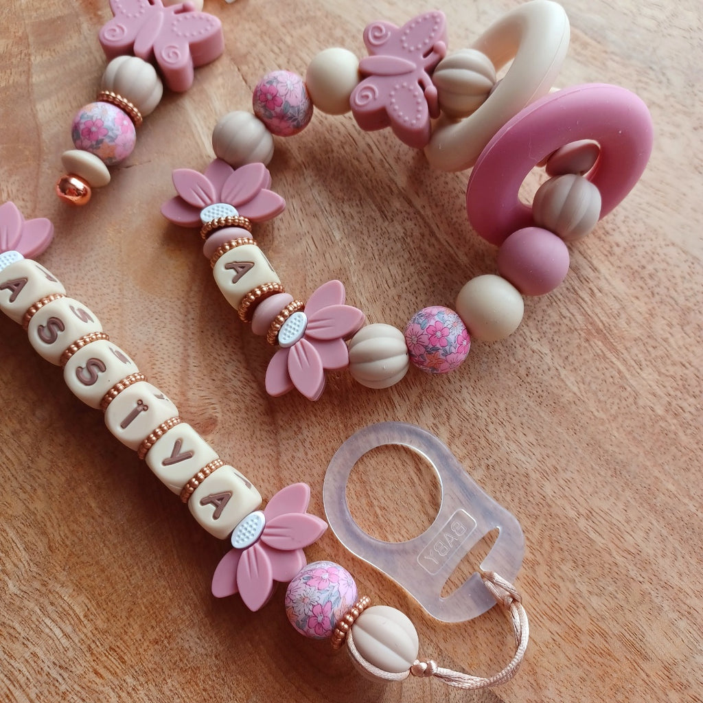 Attache tétine personnalisable avec le prénom de l'enfant, accompagné de son anneau de dentition assorti, en silicone alimentaire sans BPA. Aux couleurs vieux rose et beige