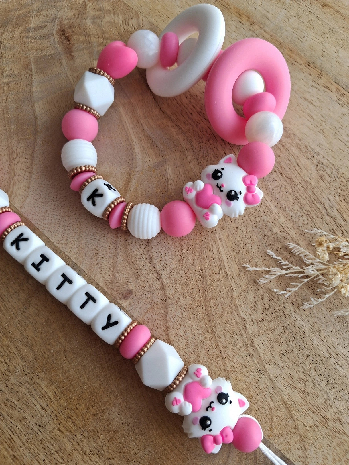 Attache tétine et anneau de dentition personnalisables en silicone alimentaire sans BPA. Aux couleurs blanc et rose fushia, perles rondes, ovales et hexagonales, anneau de dentition pour soulager les gencives de bébé. Cadeau de naissance.