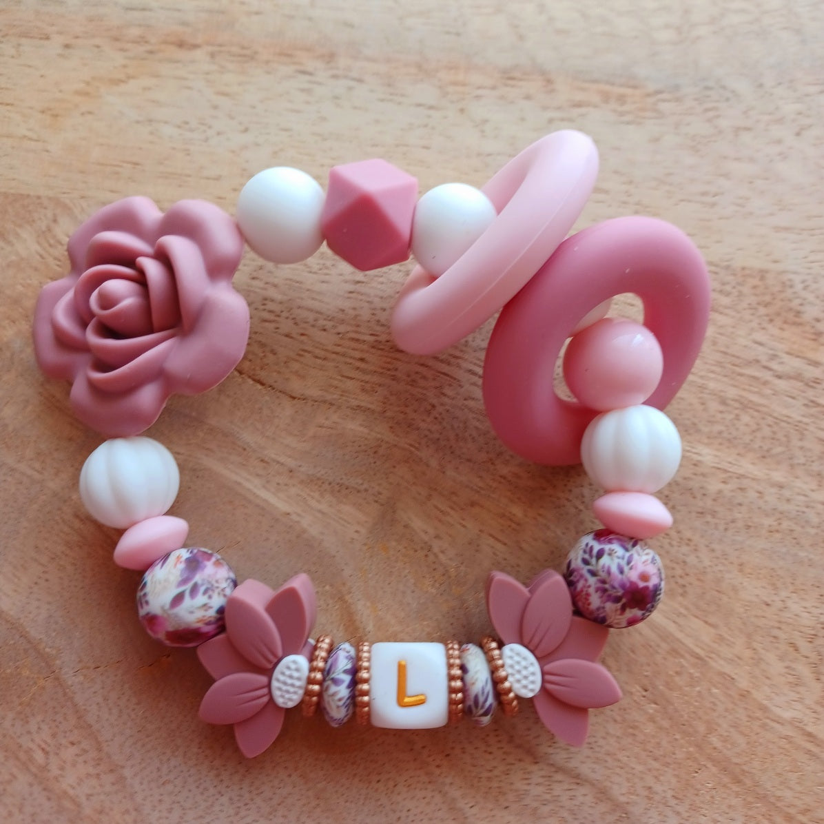 Attache tétine et anneau de dentition personnalisable avec le prénom du bébé. En silicone alimentaire sans bpa, clip robuste en acier inoxydable, perles imprimées, lettres blanche et dorées. Anneau de dentition pour soulager les dents de bébé