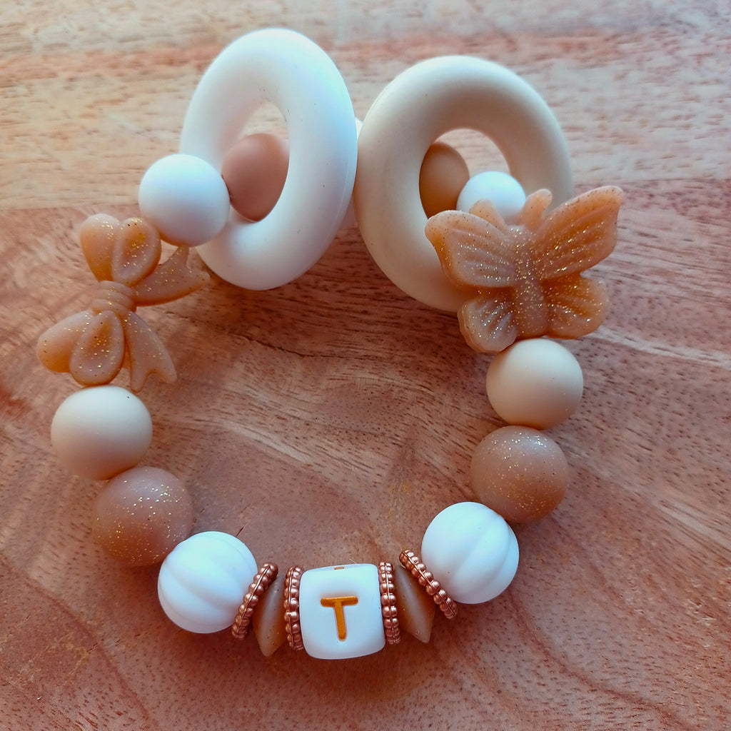 Attache tétine personnalisée en silicone alimentaire. Perles en silicone blanc, beige, papillons. Anneau de dentition assorti, personnalisable avec le prénom du bébé. Cadeau de naissance.
