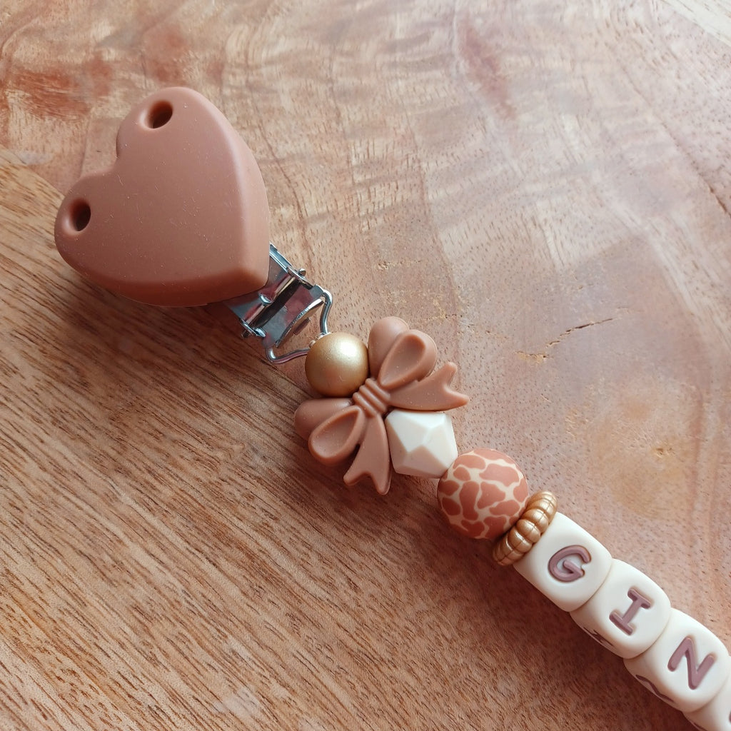 Attache tétine en silicone, personnalisable avec le prénom du bébé. Le clip est en silicone et acier inoxydable. Perles noeud et perles imprimées léopard. Superbe idée cadeau.