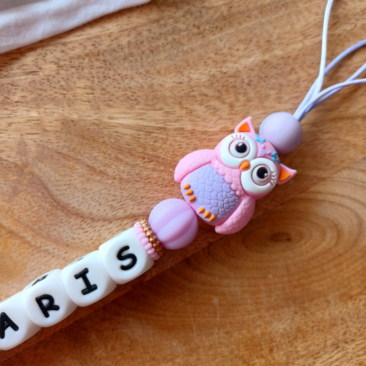 Attache tétine personnalisable en silicone alimentaire sans danger pour les bébés. Aux couleurs rose et lila, perles fleurs et hibou. Anneau de dentition avec des anneaux en silicone pour soulager les gencives des bébés. Superbe idée cadeau, babyshower, anniverssaire, baptême