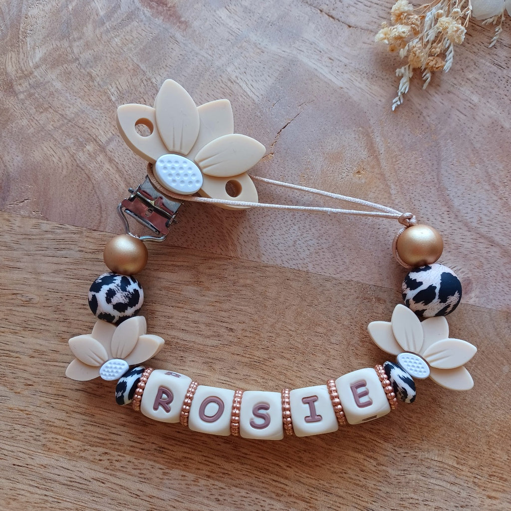 Attache tétine et anneau de dentition personnalisable avec le prénom du bébé. En silicone alimentaire sans bpa, clip robuste en acier inoxydable, en forme de fleur de lotus, perles imprimées léopard, lettres crème-choco. Anneau de dentition pour soulager les dents de bébé