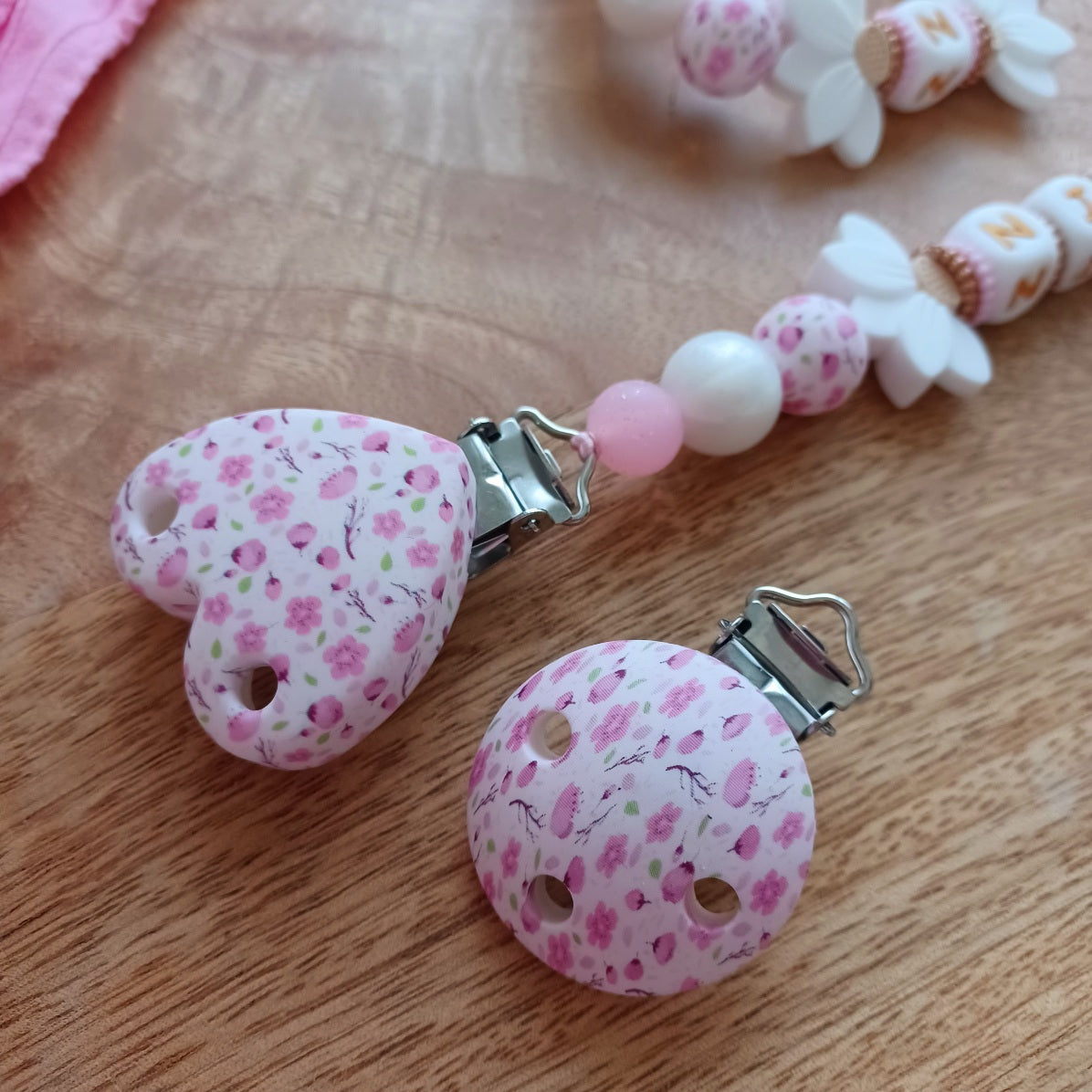 Attache tétine en silicone, pratique et sécurisée, idéale pour maintenir la tétine du bébé propre et à portée de main. Parfait comme cadeau de naissance.