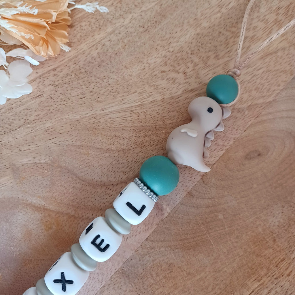 Attache tétine personnalisable en silicone alimentaire, aux couleurs vert-taupe. Clip en silicone et acier inoxydable. Idéal pour un cadeau naissance, nouveau-né.