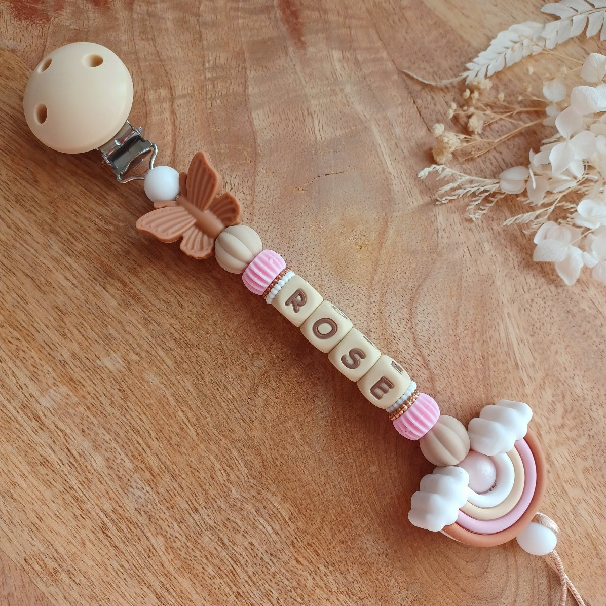 Attache tétine personnalisable avec le prénom de l'enfant, accompagné de son anneau de dentition assorti, en silicone alimentaire sans BPA. Aux couleurs vieux rose et beige