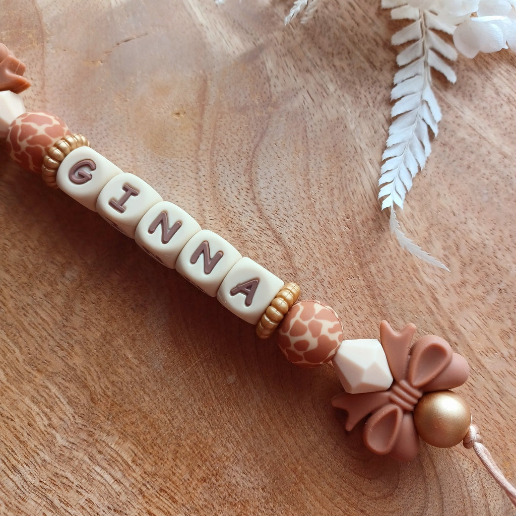 Attache tétine en silicone, personnalisable avec le prénom du bébé. Le clip est en silicone et acier inoxydable. Perles noeud et perles imprimées léopard. Superbe idée cadeau.