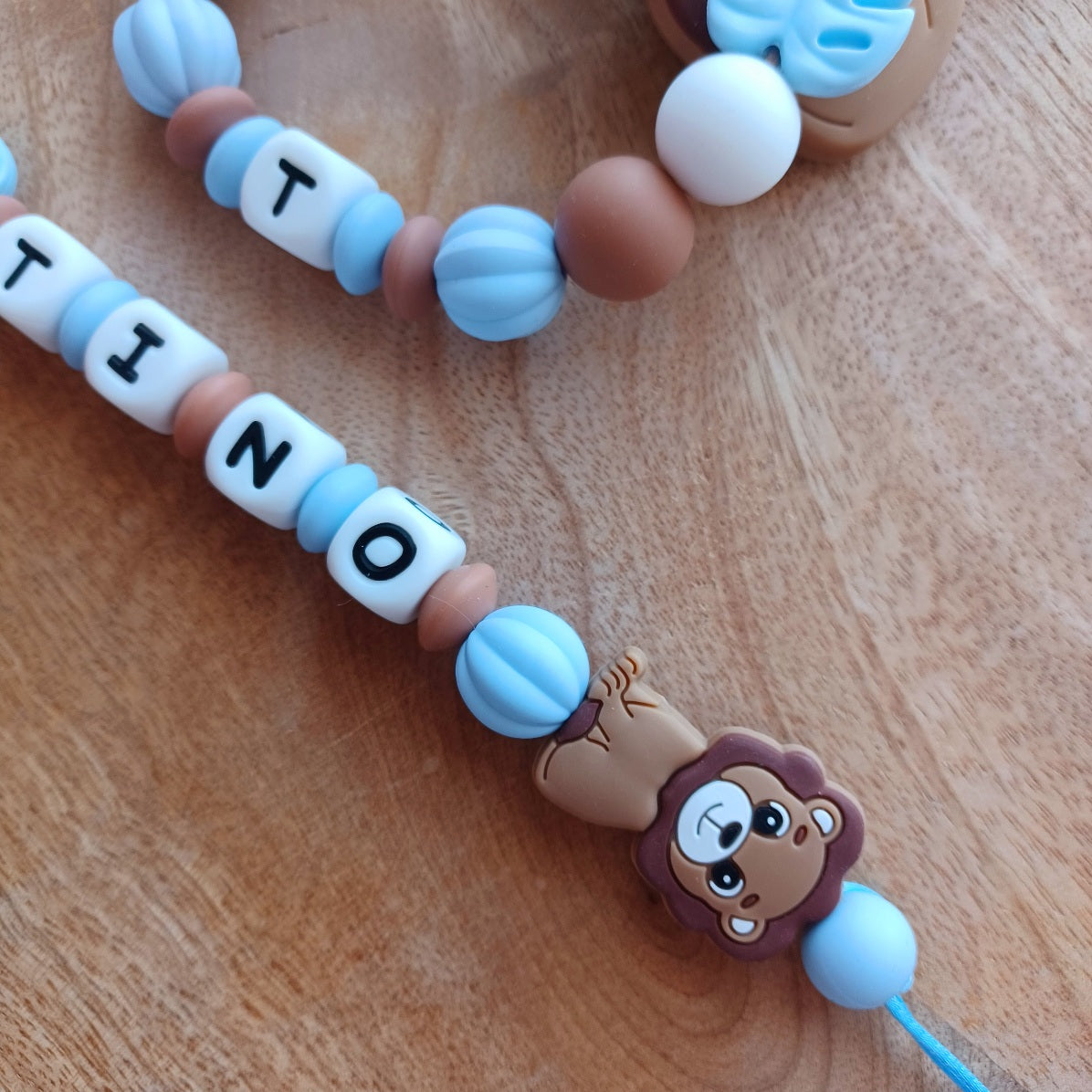 Ensemble attache tétine et anneau de dentition sur le thème Lion, en silicone alimentaire sans BPA, aux couleurs bleu, marron.  Cadeau de naissance, nouveau né.