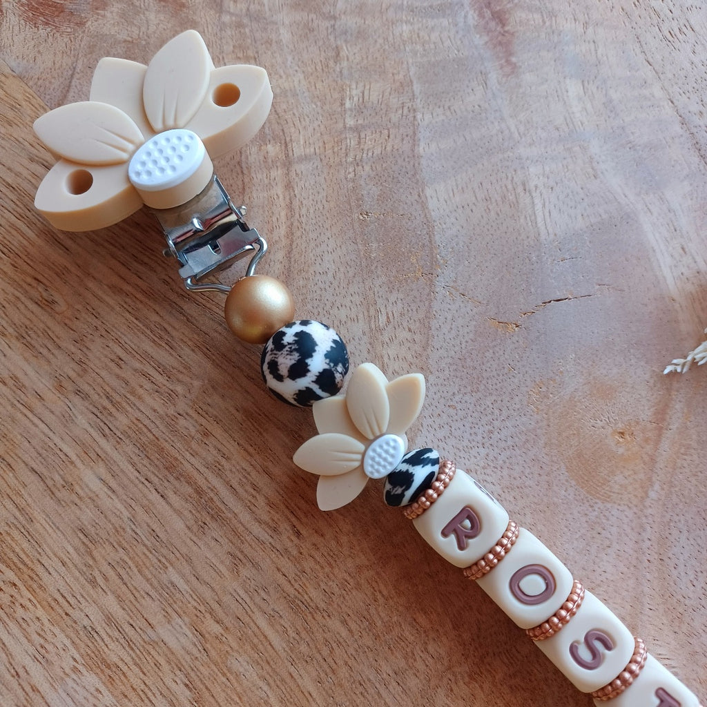 Attache tétine et anneau de dentition personnalisable avec le prénom du bébé. En silicone alimentaire sans bpa, clip robuste en acier inoxydable, en forme de fleur de lotus, perles imprimées léopard, lettres crème-choco. Anneau de dentition pour soulager les dents de bébé