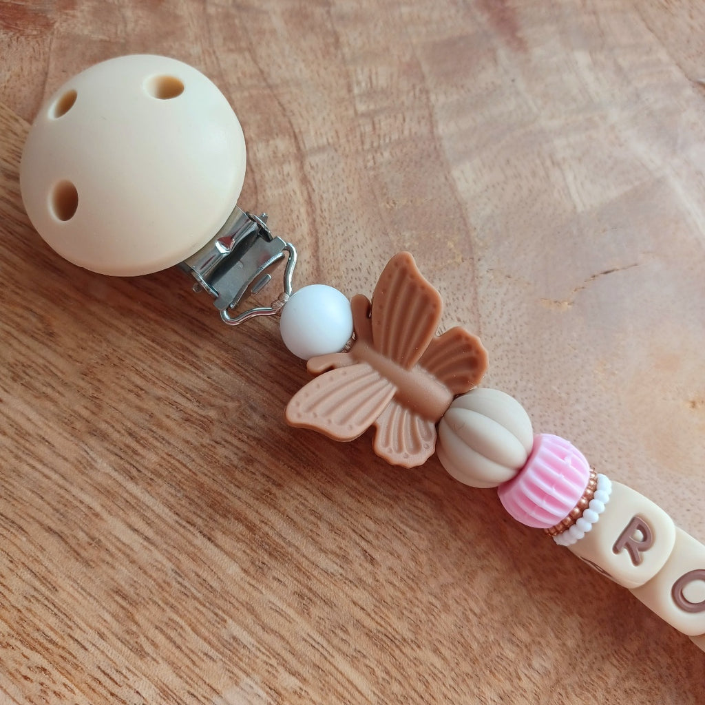 Attache tétine personnalisable avec le prénom de l'enfant, accompagné de son anneau de dentition assorti, en silicone alimentaire sans BPA. Aux couleurs vieux rose et beige