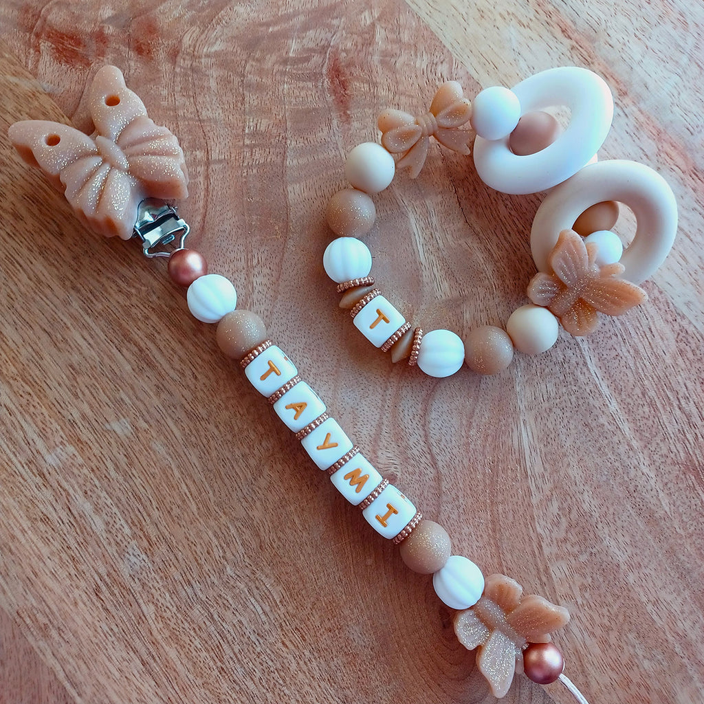 Attache tétine personnalisée en silicone alimentaire. Perles en silicone blanc, beige, papillons. Anneau de dentition assorti, personnalisable avec le prénom du bébé. Cadeau de naissance.