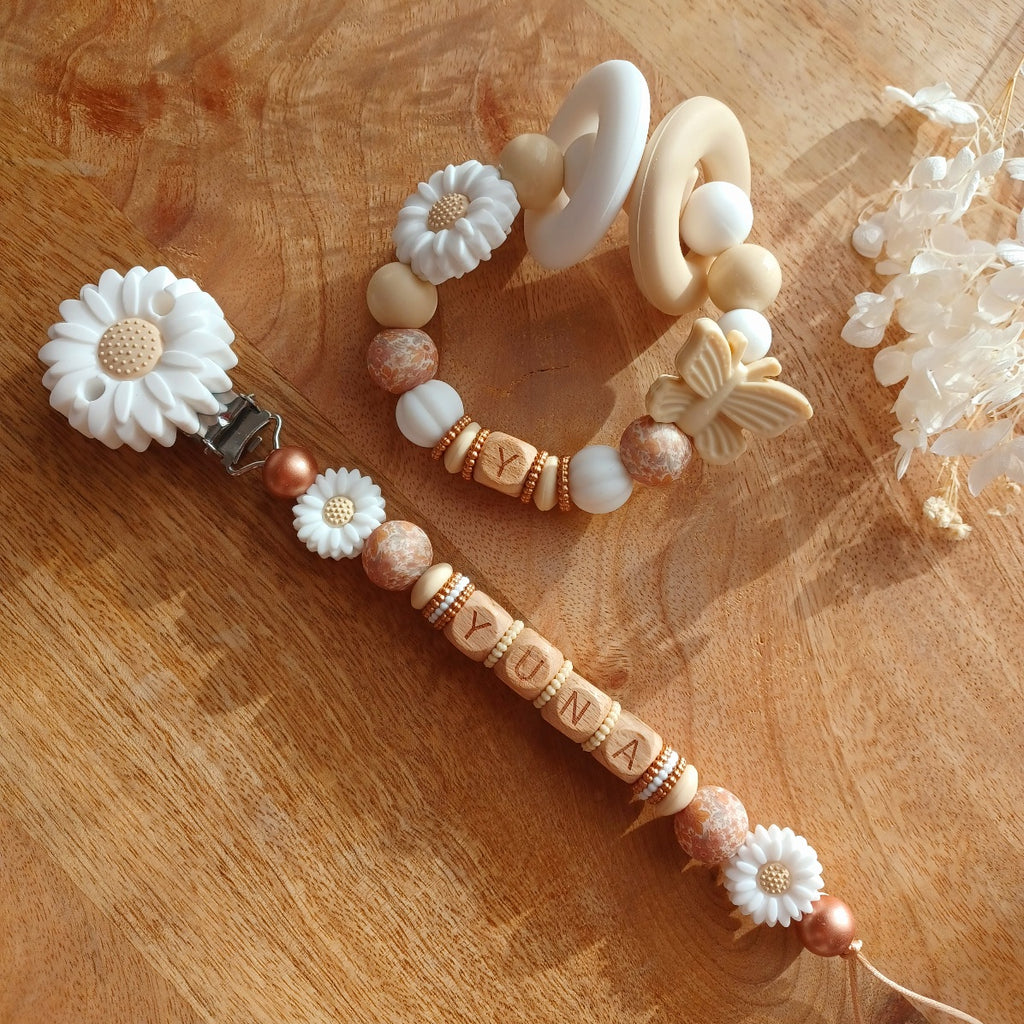 attache tetine pour bébés et enfants en bas âge. Lettres du prénom en bois, perles en silicone alimentaire en forme de fleurs marguerites, et perles imprimées fleurs