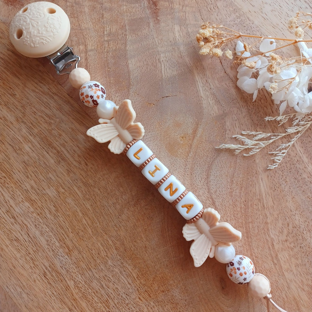 Attache tétine personnalisée prénom Lina avec papillons en silicone et perles fleuries beige pour bébé