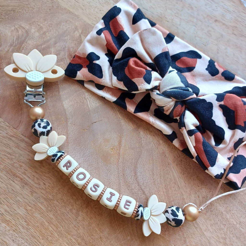 Attache tétine et anneau de dentition personnalisable avec le prénom du bébé. En silicone alimentaire sans bpa, clip robuste en acier inoxydable, en forme de fleur de lotus, perles imprimées léopard, lettres crème-choco. Anneau de dentition pour soulager les dents de bébé