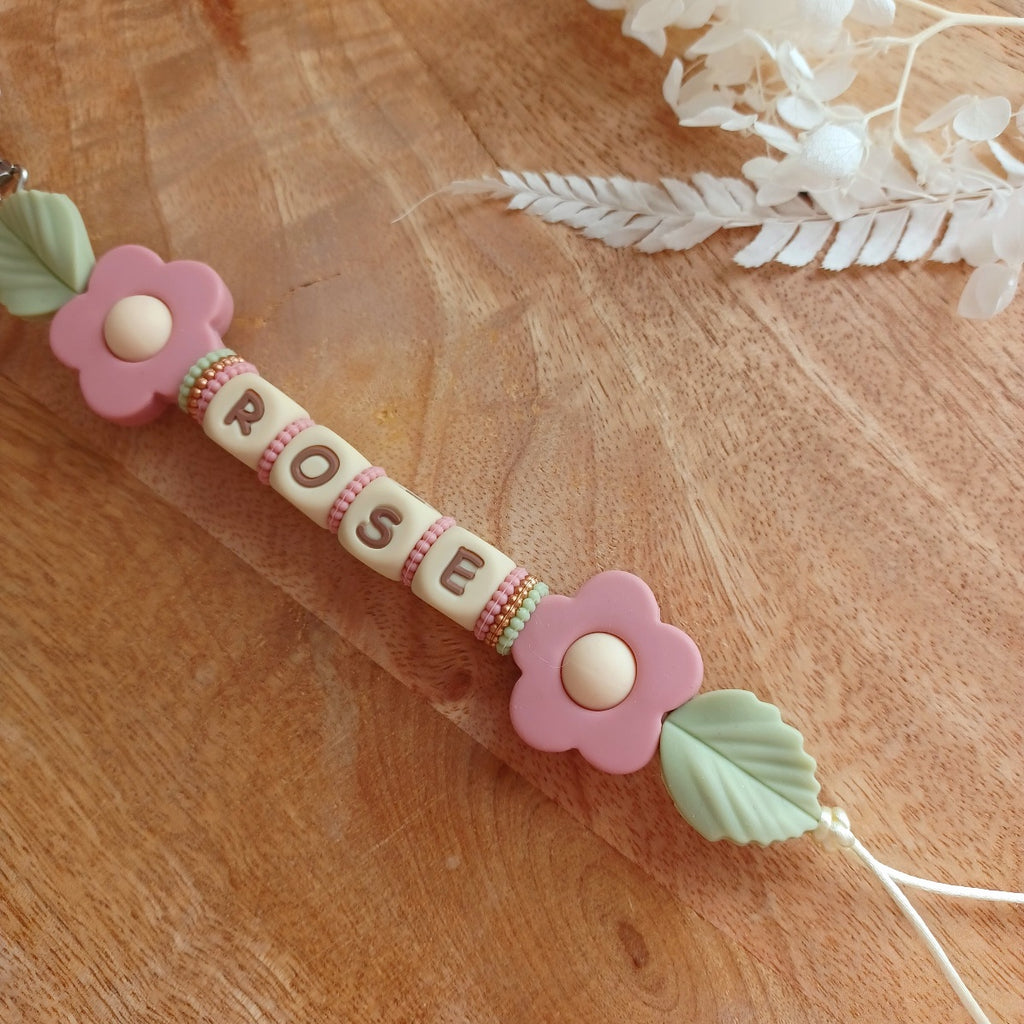 Attache tétine en silicone alimentaire sans BPA. Personnalisable avec le prénom du bébé, perles rondes, perles imprimées, perles en forme de fleurs, de noeuds, perles pailletées. Clip en silicone forme papillon. Cadeau de naissance