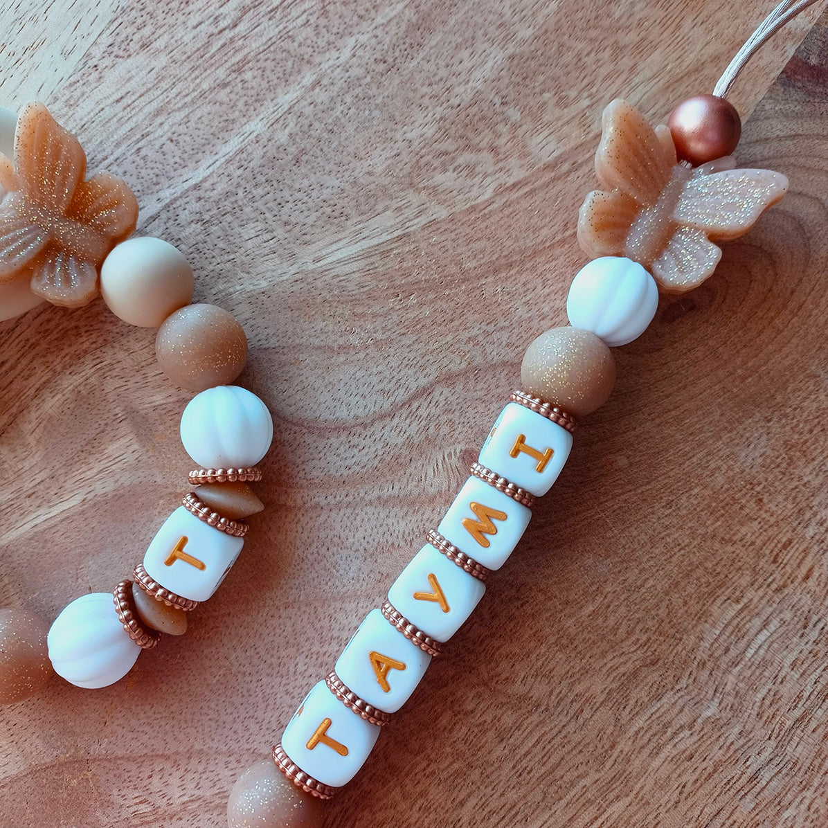 Attache tétine personnalisée en silicone alimentaire. Perles en silicone blanc, beige, papillons. Anneau de dentition assorti, personnalisable avec le prénom du bébé. Cadeau de naissance.