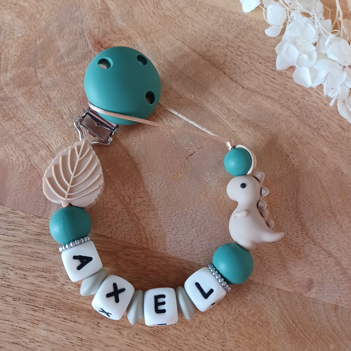 Attache tétine personnalisable en silicone alimentaire, aux couleurs vert-taupe. Clip en silicone et acier inoxydable. Idéal pour un cadeau naissance, nouveau-né.