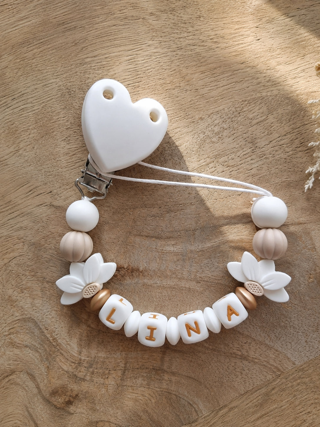 Attache Tétine Personnalisée Bébé – Fleur de Lotus blanches| Cadeau Naissance. Lina. Silicone alimentaire sans BPA. Clip en forme de coeur robuste en silicone et acier inoxydable.